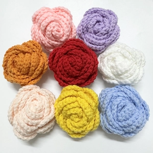 Top view of eight handmade crochet roses in various vibrant colors on a white background