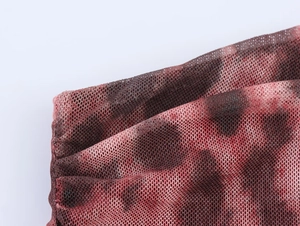 Macro shot of breathable red and black leopard mesh fabric with detailed edge stitching
