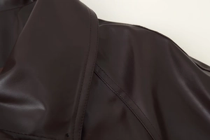 Nahaufnahme von Revers und Schulternaht an einer dunkelbraunen Vintage-Lederjacke aus PU