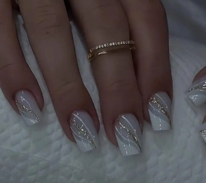 Detail of French square press-on nails with white marble texture and gold glitter edges