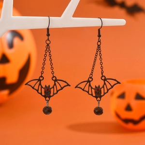 Gothic black bat earrings with red stone eyes and bead on a Halloween pumpkin background
