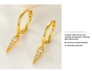 Detail of gold silver earring with hanging triangle pendant set with four 5A zircons