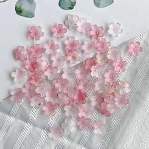 Close-up of pink gradient resin cherry blossom beads with gold foil for DIY jewelry