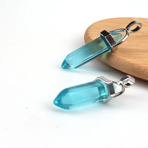 Close-up of two transparent blue hexagonal crystal pendants with silver metal clasps
