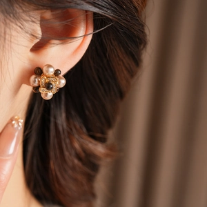 Gros plan détaillé des boucles d'oreilles vintage avec perles et logo doré élégant