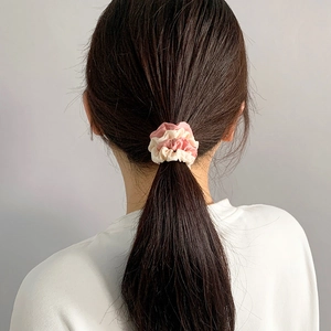 Elastico per capelli in raso rosa e beige su coda di cavallo con trama plissettata
