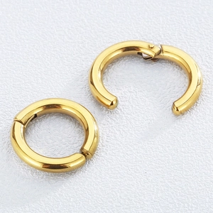 Pair of gold stainless steel hoop earrings with hinge mechanism on white background