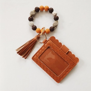 Detail of beaded wristlet with leather wallet, leopard print charm and golden ring