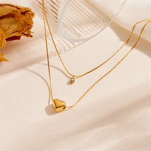 Double-layered gold heart necklace with small diamond accents and elegant pendant