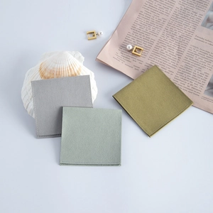 Macro view of velvet jewelry pouches in gray and olive green on white background