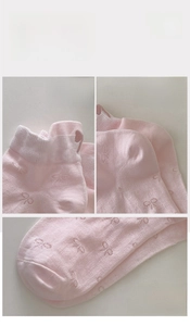 Detail of pink cotton sock showing high elastic cuff, reinforced heel, and bow pattern