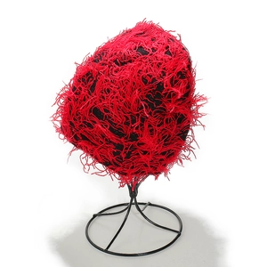 Detail of red tassel fringe on black knit balaclava hat showing texture and design