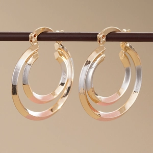 Three-tone double hoop earrings in gold, silver, and rose gold finishes with hinge closure