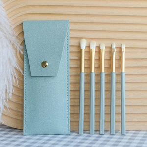 Detail of 5-piece soft blue eye makeup brush set with elegant gold ferrule and pouch