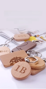 Macro shot of laser-engraved wooden keychains with various custom patterns and key rings