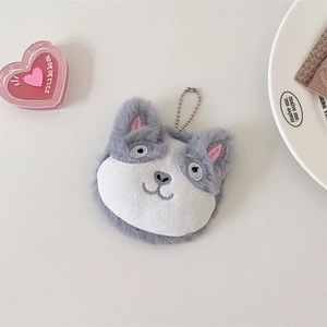 Detail of plush husky doll makeup mirror with metal bead chain on beige surface