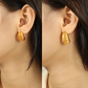 Golden twisted croissant hoop earrings with metallic texture for a bold fashion statement