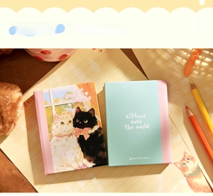 Detailed view of two A7 notebooks featuring cute cat illustrations and pastel colors.