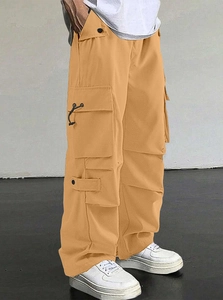Detail view of khaki tactical cargo pants with utility pockets and decorative straps