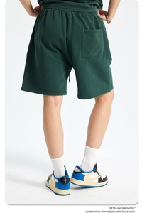 Macro detail of dark green heavyweight cotton shorts showing fabric texture and back fit