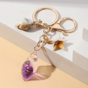 Detailed view of luminous purple shell and starfish keychain with gold lobster clasp