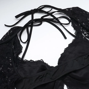 Close-up of black lace backless jumpsuit with intricate criss-cross straps and floral lace