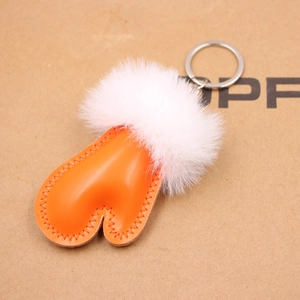 Detail of orange leather and white plush heart keychain with silver metal ring