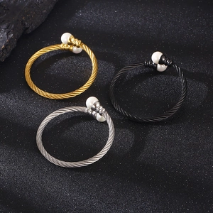 Detailed trio of twisted cable wire bracelets in gold, silver, and black with pearls