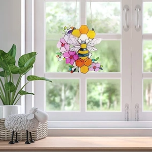Detail of acrylic bee suncatcher showing light transmission on a window