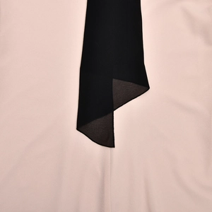 Détail du tissu bicolore rose et noir montrant la texture douce et les finitions nettes