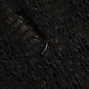 Dettaglio macro in pizzo nero con cerniera invisibile e fodera color oro