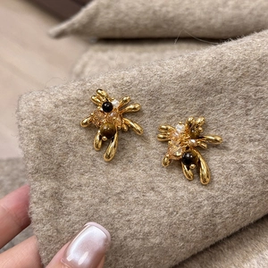 Close-up of 18K gold-plated fireworks earrings with tiger eye stone and pearls