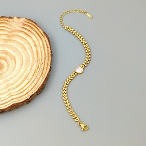 Detailed view of the 18K gold-plated leaf chain bracelet with heart shell inlay detail