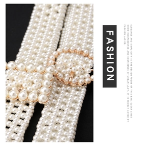 Macro shot of white woven pearl belt with elegant gold square buckle for women