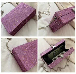 Detail of purple glitter box bag showing starry sequins and silver chain strap