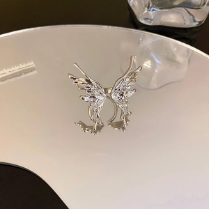 Macro detail of silver liquid metal style butterfly ring with asymmetric hollow wings