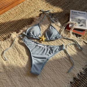 Close-up of glittery light blue bikini with starfish detail and size S label