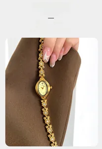 Detail view of oval crystal watch with vintage floral chain bracelet on female hand