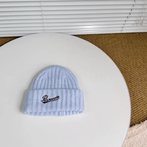 Close-up of sky blue ribbed knit beanie featuring dark Pensecolo script embroidery detail