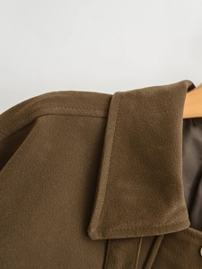 Detail von Kragen und Nähten der braunen Wildlederimitat-Fliegerjacke auf Holzkleiderbügel