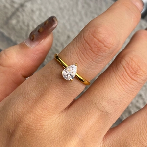 Detailed close-up of a golden stainless steel ring featuring a pear-cut zircon stone