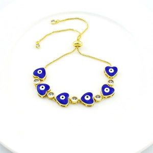 Detail of gold adjustable evil eye bracelet with blue enamel hearts and zircons