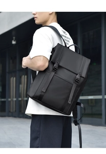 Detailed outdoor view of a black waterproof business backpack with double buckle flap design
