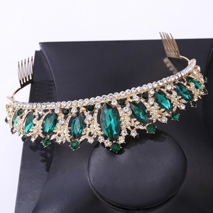 Close-up of golden bridal crown featuring emerald green gems and sparkling clear rhinestones