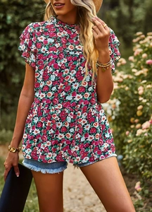 Outdoor portrait of floral ruffle sleeve top and denim shorts in a garden