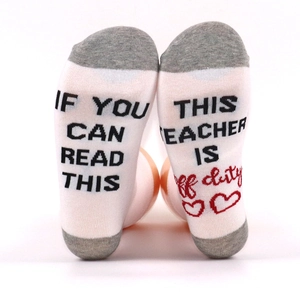 White cotton crew socks with 'IF YOU CAN READ THIS TEACHER IS OFF DUTY' funny slogan