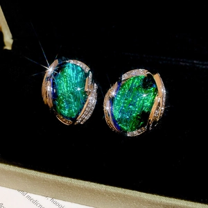 Détail de boucles d'oreilles vintage en résine avec pierres vert émeraude et diamants étincelants