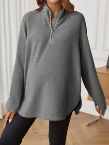 Detail of dark grey fleece maternity top with half-zipper and thumbhole cuffs