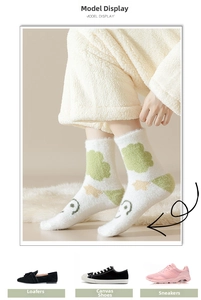 Close-up of cozy white mink fleece socks with green cloud pattern for home wear
