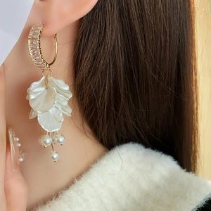 Macro detail of cascading white resin petals with zircon and elegant pearl tassels